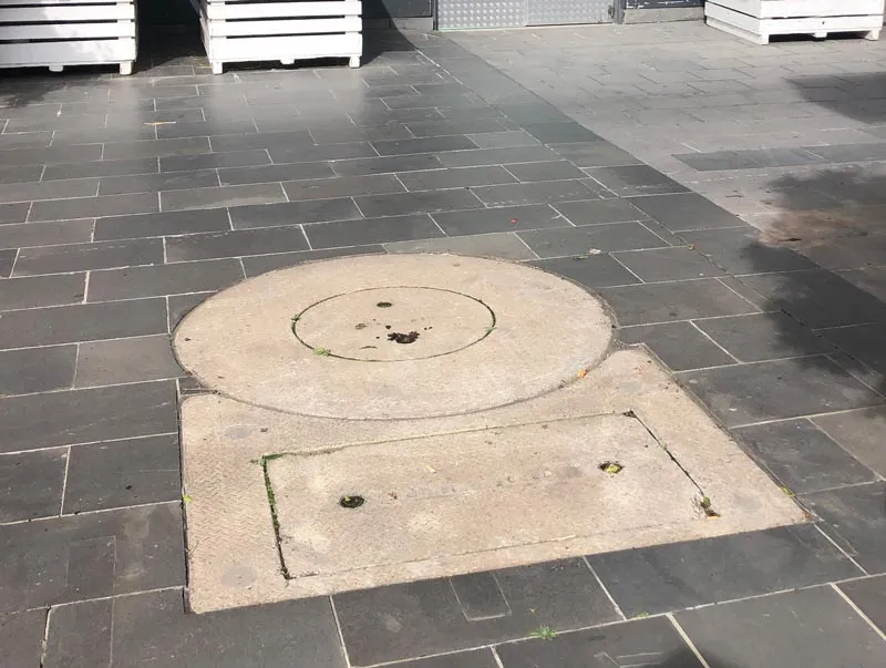 Close view of a concrete tank access lid in paving